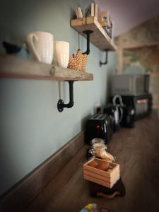 a kitchen with wooden floors and shelves with food on the floor at The Stables at Ballyward Croft in Ardkeen