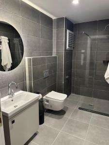 a bathroom with a toilet and a sink and a mirror at CALİ ROYAL OTEL in Denizli