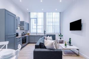 a living room with a couch and a kitchen at Modern 2-bedroom Apt In The Heart Of City Centre in Liverpool +108 photos
