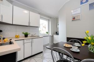 a kitchen with white cabinets and a black table at Villa Baltica I in Rewa