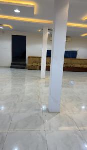 a large empty room with a screen and columns at شاليه 1 in Al Ḩazm