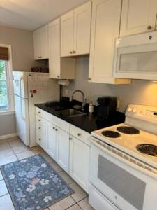 a kitchen with white cabinets and a white stove top oven at Chicks Beach Retreat in Virginia Beach