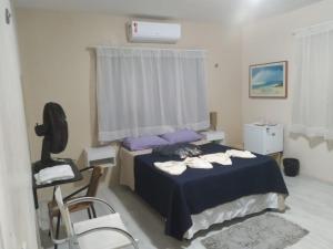 a bedroom with a bed with purple pillows and a chair at Pousada Suítes Meireles in Fortaleza