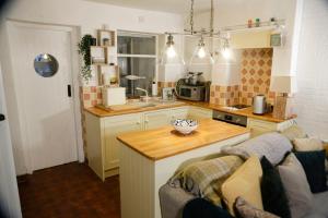 a kitchen with a couch and a table in a kitchen at Water View Cottage, Conwy in Conwy