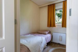 - une petite chambre avec 2 lits et une fenêtre dans l'établissement Chalet Enzerinck - rustig, comfortabel en knus chalet in het bos 2p, à Vorden