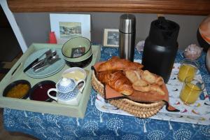 オーブナにあるL'Arche de Noéのパンとコーヒーのバスケット付きのテーブル