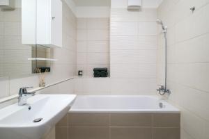 a white bathroom with a sink and a bath tub at NEW home by the Liget in Budapest