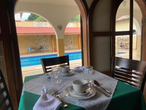 Pousada Hotel Casa Central في ساو بينتو دو سابوكاي: طاولة قماش الطاولة الخضراء على طاولة مطلة على مسبح