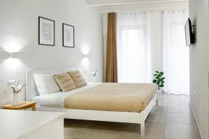 biała sypialnia z łóżkiem i oknem w obiekcie DoMe Affittacamere w mieście Iglesias