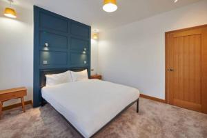 a bedroom with a large white bed and a blue headboard at Home away from home in Liverpool