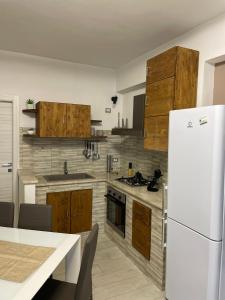 una cucina con armadi in legno e frigorifero bianco di LA CASA DI GIUSEPPE VISTA MARE a Marinella di Selinunte
