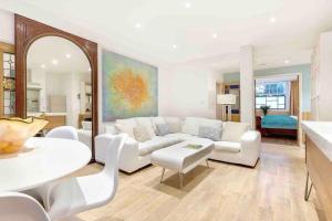 Una sala de estar con un sofá blanco y una mesa. en Eclectic family home in the heart of Notting Hill, en Londres