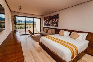 a bedroom with a large bed and a large window at Hacienda Las Flores Valle de guadalupe in El Porvenir