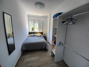 Dormitorio pequeño con cama y espejo en Apartamento Arrufat&Osorio, en Granada