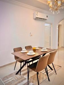 comedor con mesa de madera y sillas en Rawda 2 Bed-Room Apartment in Jeddah, 100 meter to supermarket en Yeda