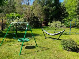 twee hangmatten in een tuin met bij Wypoczynkowy Dom Rodzinny in Ińsko