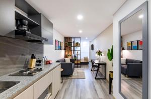 een keuken met een aanrecht en een woonkamer bij gAº Maravilloso apartamento en zona T in Bogota