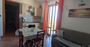 a kitchen and dining room with a table and a couch at Appartamento LG in San Vito lo Capo