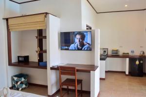 a room with a tv hanging on the wall at Vivi Bungalows Resort in Nai Harn Beach