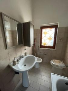 ein Badezimmer mit Waschbecken und Toilette und einem Fenster in der Unterkunft Parco Nonna Nina in Castellammare di Velia + 16 Fotos