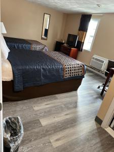 1 dormitorio con 1 cama y suelo de madera en Wickford Motor Inn, en North Kingstown