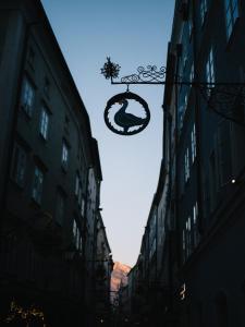 a sign in the middle of a street with buildings at artHotel Blaue Gans in Salzburg