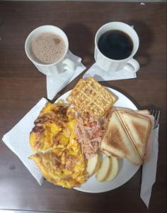a plate of breakfast food and a cup of coffee at Hotel Inter del Café in Pereira