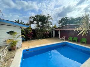 a large blue swimming pool next to a house at Las cabinas del sueño in Nicoya