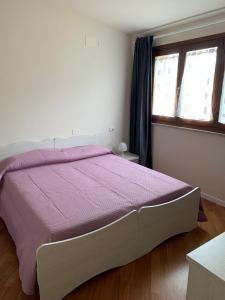 a bedroom with a large bed with a purple comforter at le tamerici B&B in Ancona +7 photos