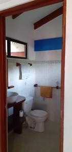 y baño con aseo y lavamanos. en Las cabinas del sueño, en Nicoya