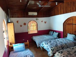 a room with two beds and a window at Las cabinas del sueño in Nicoya