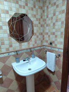 a bathroom with a sink and a mirror at Casa del Caño 