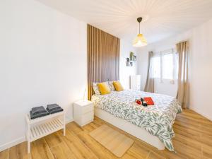a white bedroom with a bed and a window at Apartment on Beach Mijas in Mijas Costa