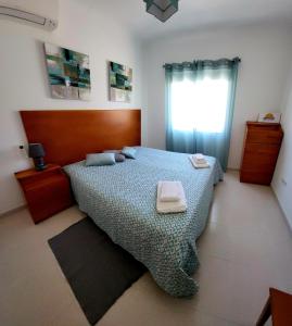 a bedroom with a bed with two towels on it at Apartamento Sunrise in Altura