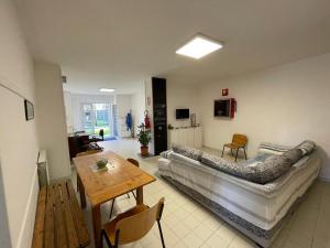 a living room with a bed and a table in it at Acqua Piatta - L'Ostello del Canoa in Ivrea
