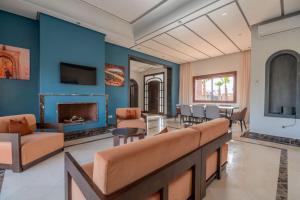 een woonkamer met blauwe muren en een tafel en stoelen bij Mandar Atlas in Marrakesh