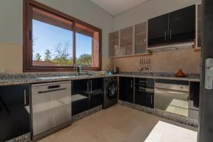 uma cozinha com utensílios de aço inoxidável e uma janela em Mandar Atlas em Marrakech
