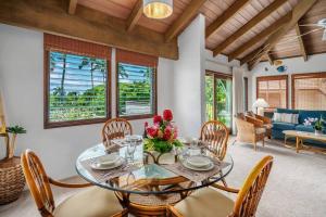 une salle à manger avec une table et des chaises en verre dans l'établissement Po'ipu Paradise, Ocean View Retreat, Beach Access, à Koloa