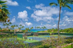 - un court de tennis avec des palmiers et l'océan dans l'établissement Po'ipu Paradise, Ocean View Retreat, Beach Access, à Koloa