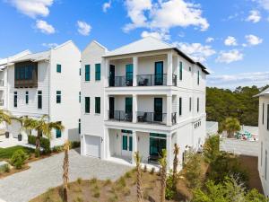 an exterior view of a white house with palm trees at Seven Palms Pinnacle in Inlet Beach