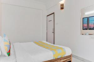 a white bedroom with a bed and a mirror at OYO Home Dazzling Studios Near Airport Near Pune Airport in Lohogaon