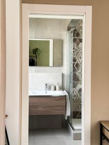a bathroom with a sink and a mirror at Casa Febo, in centro con parcheggio privato a 200 mt dal mare in Bordighera