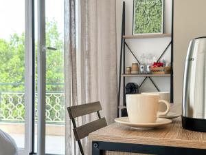 a table with a cup of coffee on it next to a window at Casa Febo, in centro con parcheggio privato a 200 mt dal mare in Bordighera
