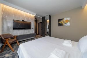 a hotel room with a bed and a tv on the wall at Apartmani 8 Beograd in Jajinci