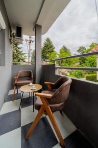 Jajinci的住宿－Apartmani 8 Beograd，阳台配有2把椅子和桌子