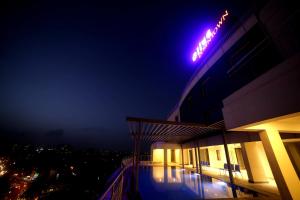 a building with a neon sign on top of it at night at Olive Downtown in Cochin