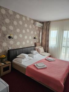 a bedroom with a large bed with a red blanket at Casa Amiral in Sulina