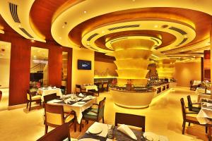 a restaurant with tables and chairs and a large ceiling at Olive Downtown in Cochin