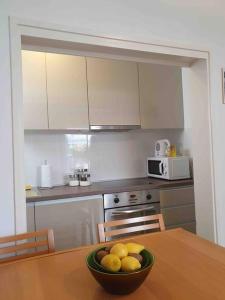 a kitchen with a bowl of fruit on a table at Apartman Zvonimir with a beautiful sunset in Silba