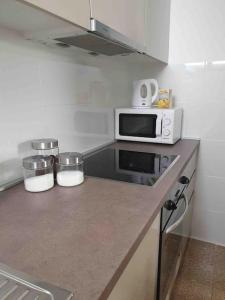 a kitchen with a counter top with a microwave at Apartman Zvonimir with a beautiful sunset in Silba